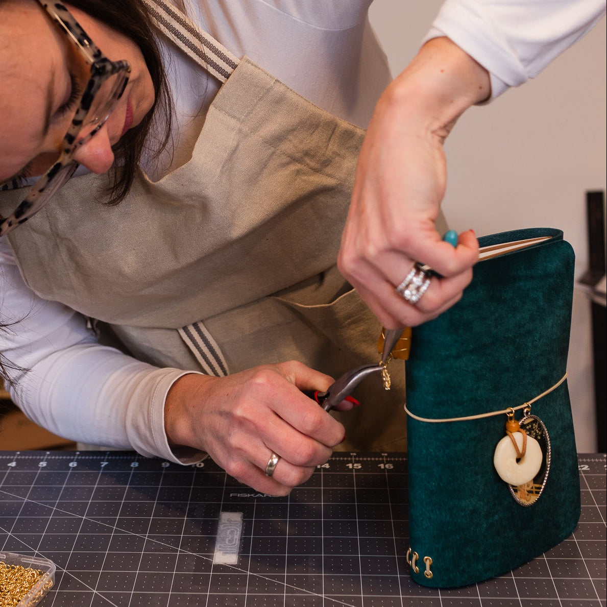 Person working on a craft project with materials on a table